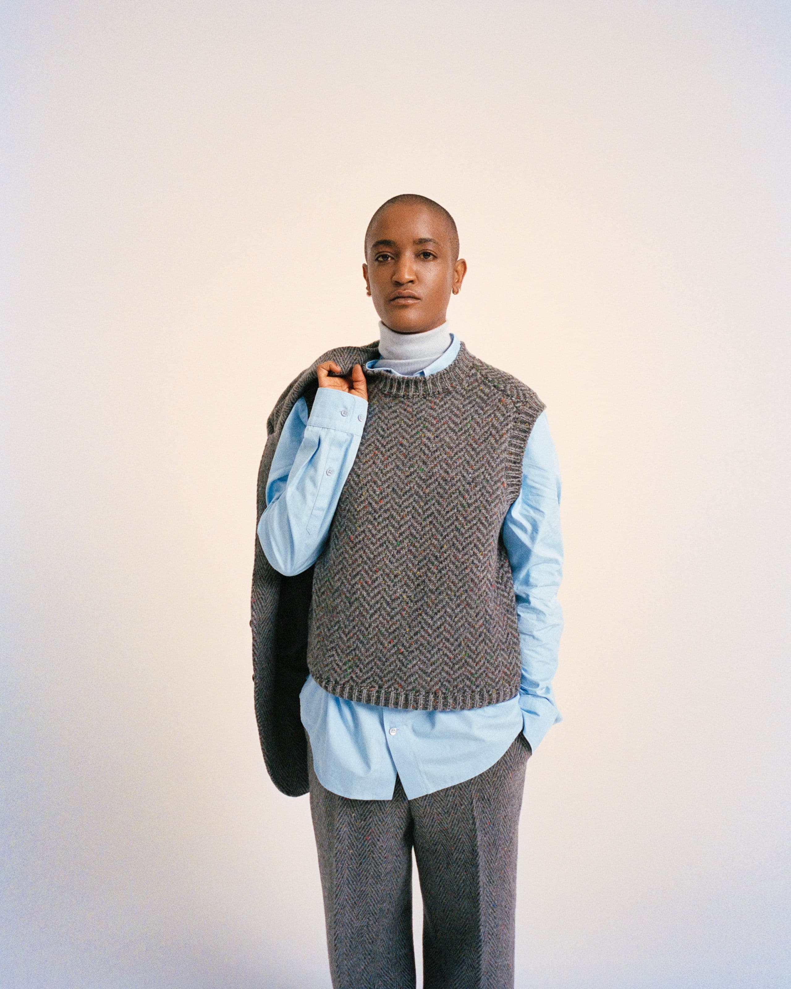 Syd in a sweater vest holding a jacket