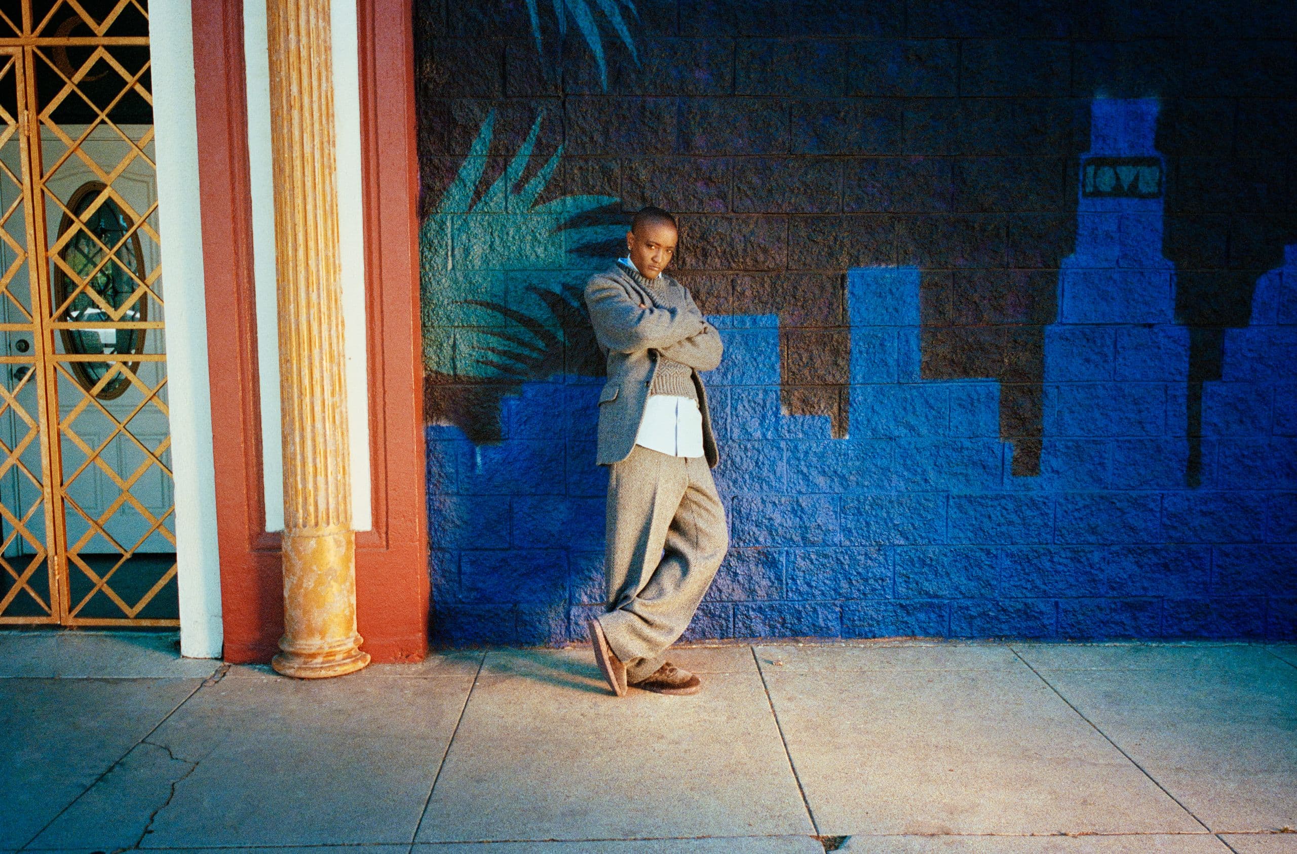 Syd leaning against a blue wall